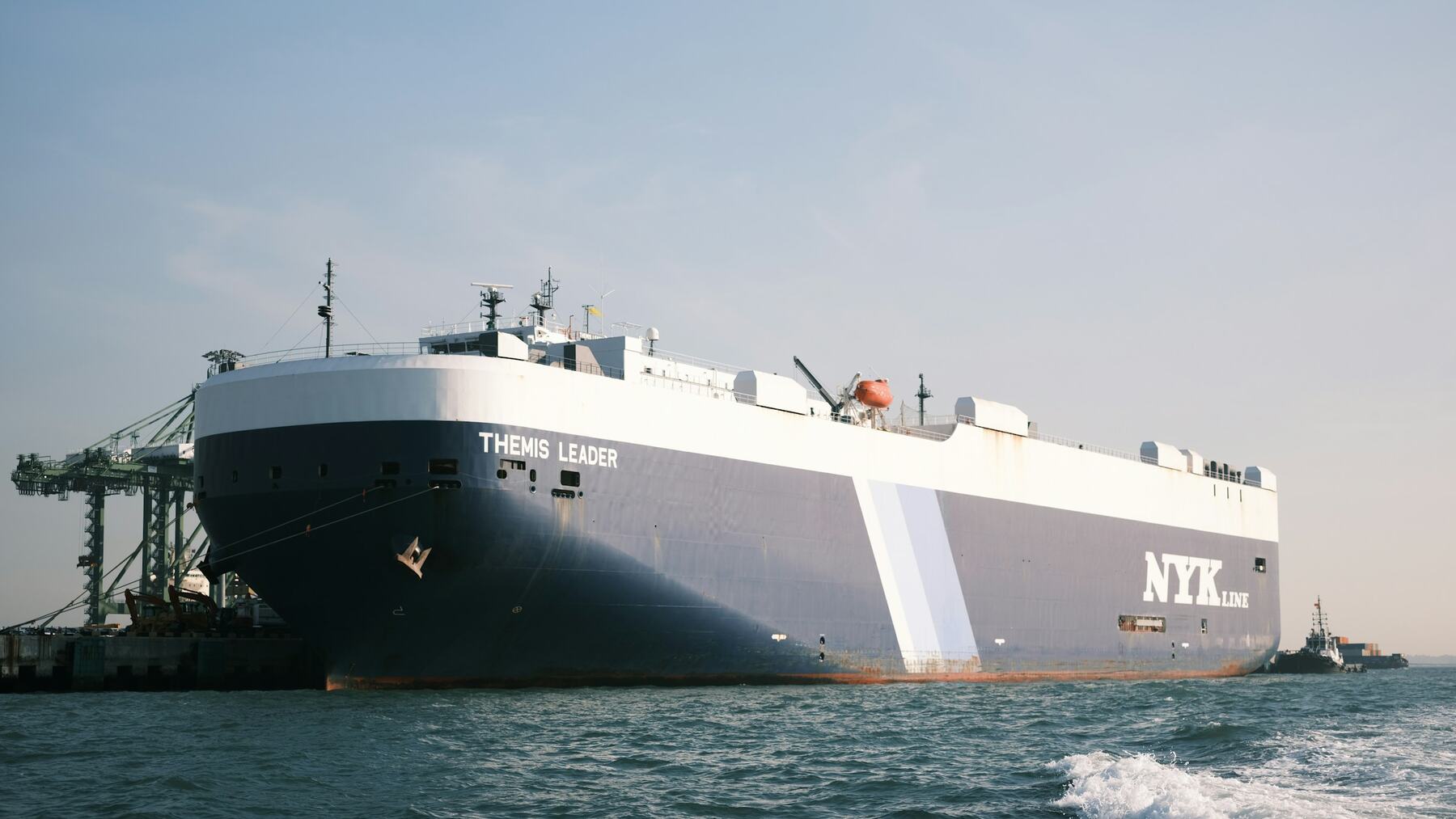 Vehicle carrier ship moored alongside port cranes