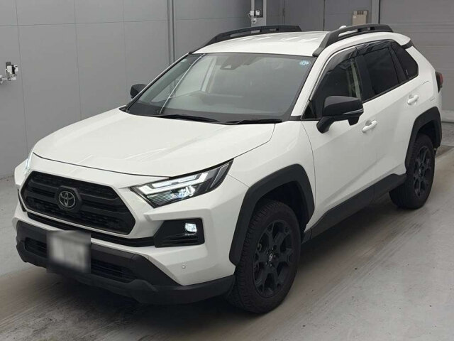 White Toyota RAV4 photographed from the front three-quarter in an indoor vehicle bay